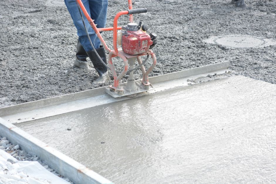 Concrete finisher smoothing a fresh slab with a trowel