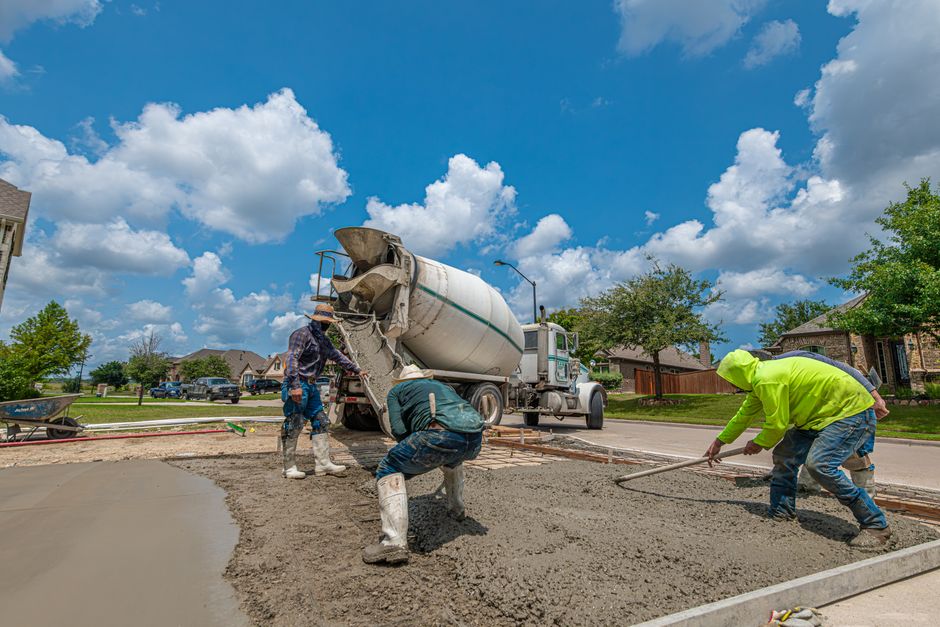 Concrete crew finishing a fresh driveway pour